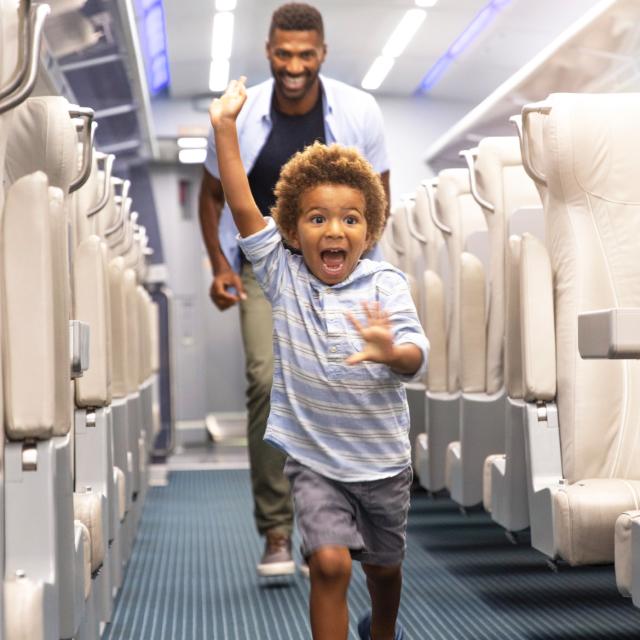 Child in aisle of Brightline train