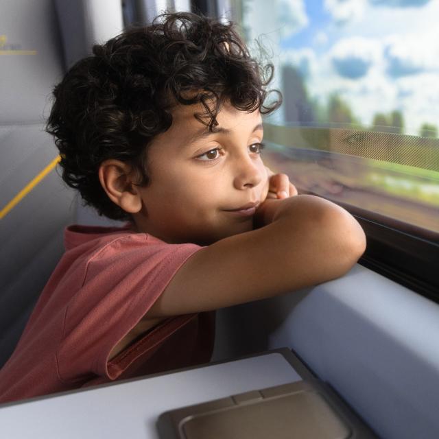 Boy looking out window of Brightline train