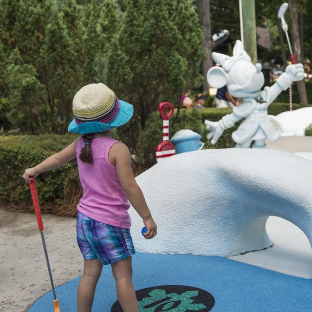 A little girl golfing at Disney's Winter Summerland Miniature Golf