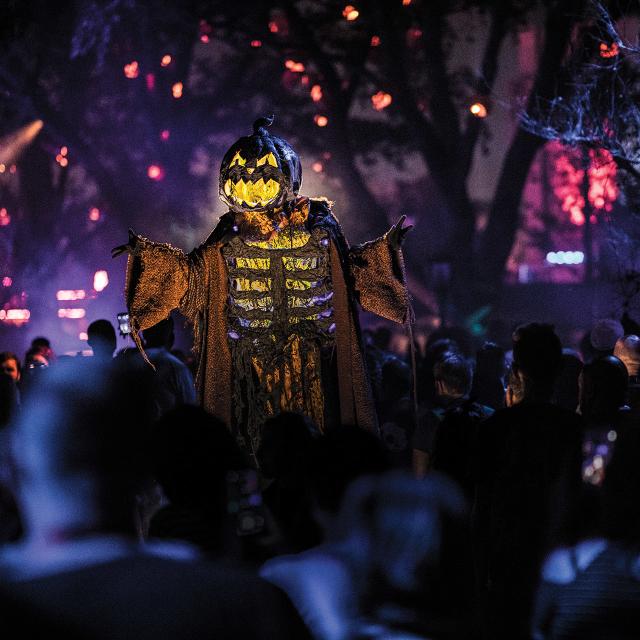 HHN18 - PhotoSht - Assets for 2019 102418 Twisted Traditions Pumpkin Stiltwalker Night time Dusk