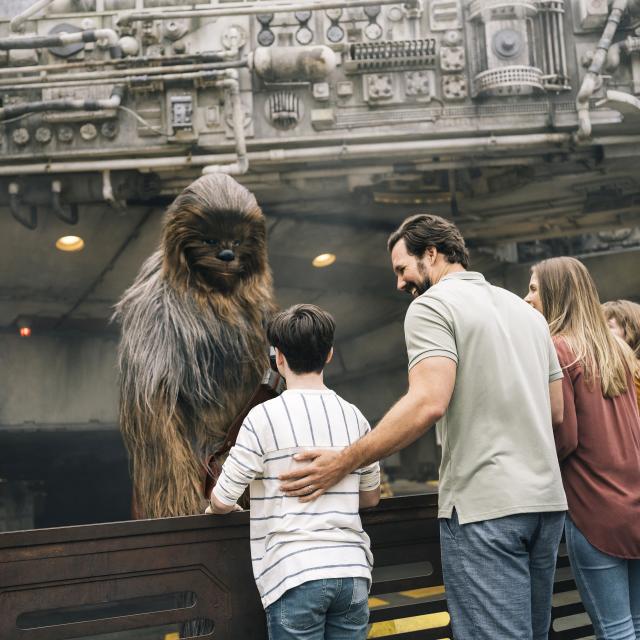 A family meeting Chewbacca in Star Wars: Galaxy's Edge at Disney's Hollywood Studios in the Walt Disney World Resort.