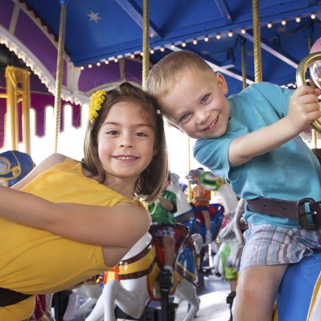 two children riding on a carousel