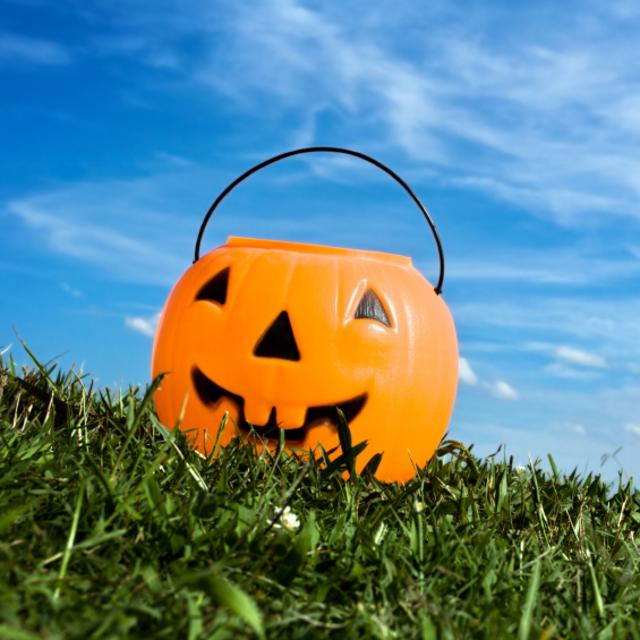 Plastic pumkin candy holder under blue skies