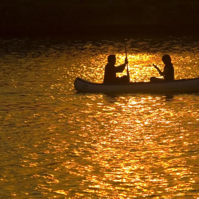 Two people in a canoe at sunset