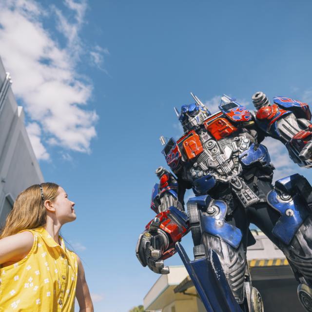 girl looking up at optimus prime transformer