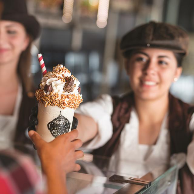 Serving a customer a milkshake at Toothsome Chocolate Emporium at Universal CityWalk